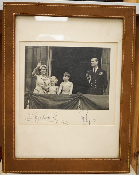 A framed photograph of Queen Elizabeth II, Prince Philip, King Charles and Princess Anne, signed by both the Queen and Prince Philip in ink, with each signature under their relevant image and dated 1954, contained within